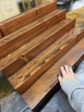 Handcrafted fragrance collection tiered display and storage shelf with hidden storage drawer closed