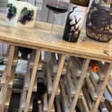Close up of handcrafted reclaimed wood wine bottle rack showing storage shelf top and large bottle capacity of wine rack