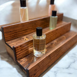 Handcrafted reclaimed wood fragrance display shelf with tiered steps for perfume and cologne bottles