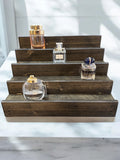 Handcrafted reclaimed wood fragrance display shelf with tiered steps for perfume and cologne bottles